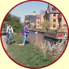 Cyclist on canal towpath, next to fisherman